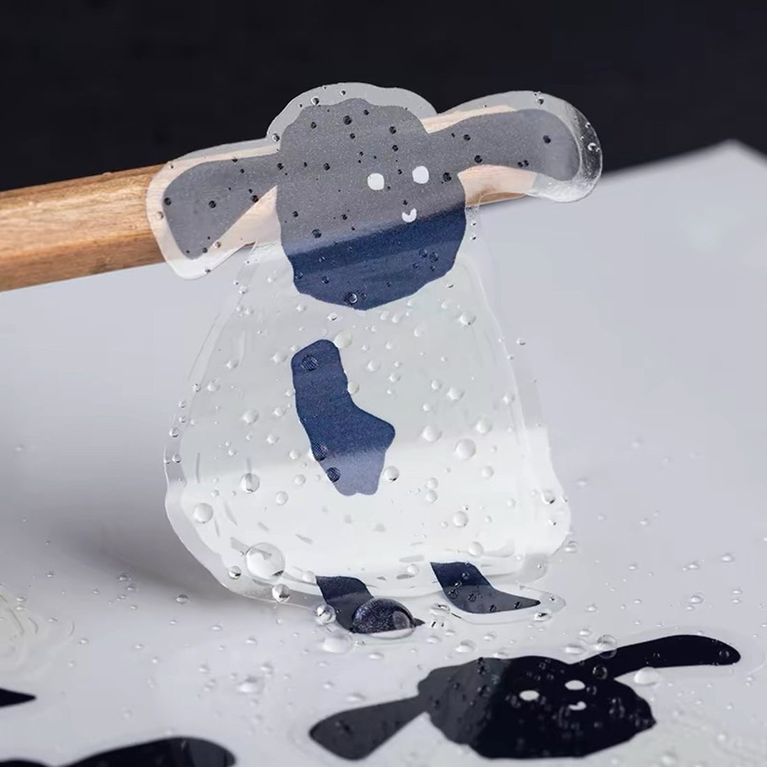 Custom die-cut clear sticker of a lamb design with water droplets showing waterproof film