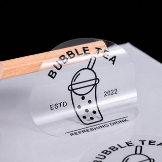 Transparent round sticker with line-art logo on clear waterproof film