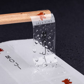 Clear waterproof sticker with minimal text design, water beading on transparent film