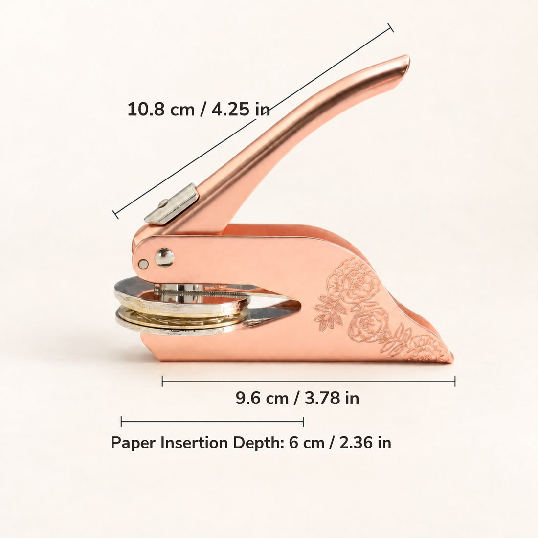 A rose gold embosser with measurements: 10.8 cm long, 9.6 cm wide, 6 cm paper insertion depth