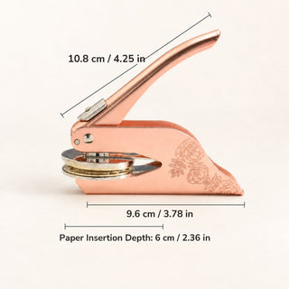 A rose gold embosser with measurements: 10.8 cm long, 9.6 cm wide, 6 cm paper insertion depth