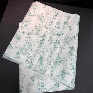 Folded stack of 17gsm custom tissue paper sheets printed with a green botanical pattern
