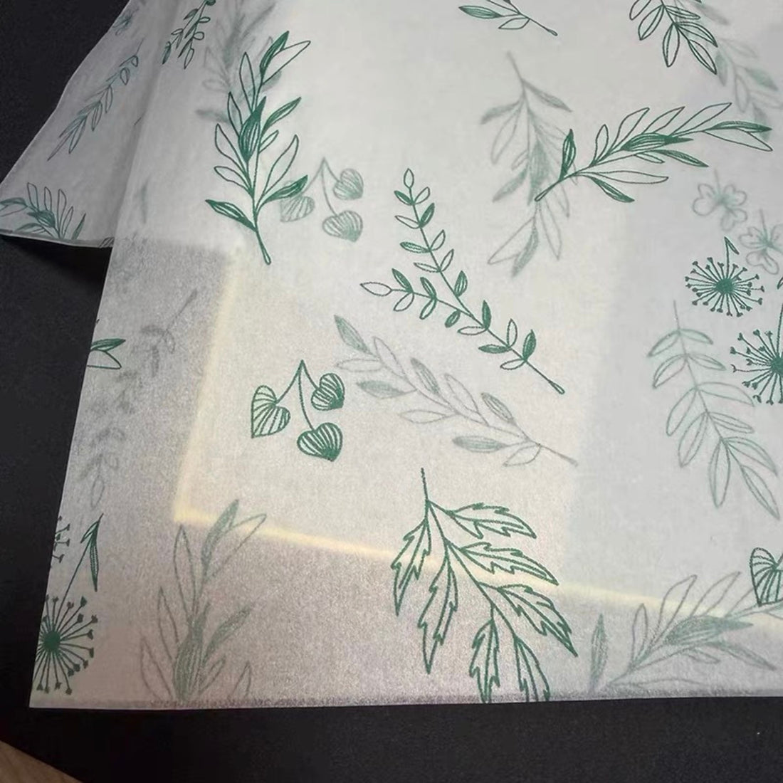 Close-up of a green botanical print on lightweight 17gsm custom tissue paper
