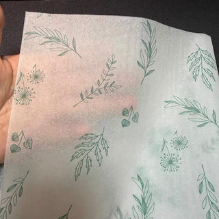 Sheer 17gsm custom printed tissue paper held up to show its soft translucency
