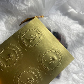 Gold metallic sticker sheet with embossed round crest emblems, raised emboss on gold foil paper