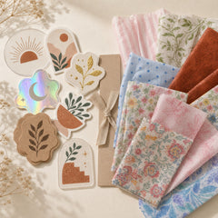 Pakvel sample pack — assorted sticker finishes and printed tissue paper swatches on cream