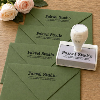 Four green envelopes stamped with a custom pre-inked stamp, shown beside the stamp
