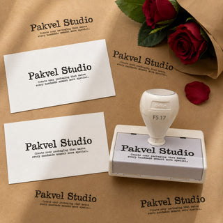 Custom pre-inked stamp with impressions on white cards and kraft paper, beside red roses