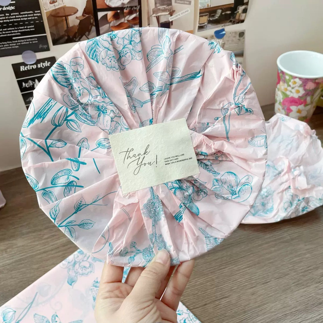 A bundle wrapped in pink patterned tissue paper with a Thank You card