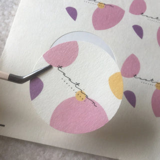 Textured paper circle sticker with colorful petal artwork, tactile felt paper finish
