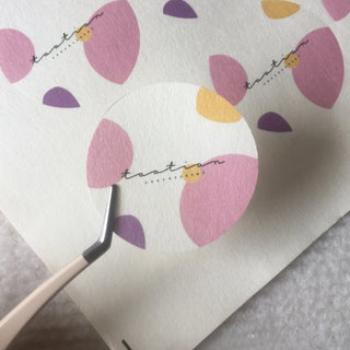 Textured paper sticker with full-color petal artwork, die-cut circle on felt-textured art paper