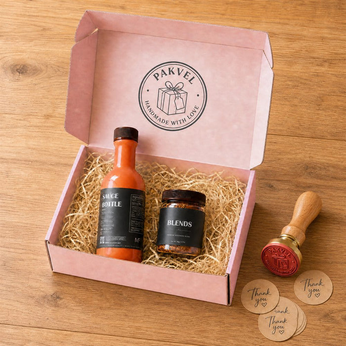 A small-batch sauce bottle and spice jar with custom labels, gift-boxed in a branded mailer with crinkle paper, a wax seal stamp and thank-you stickers